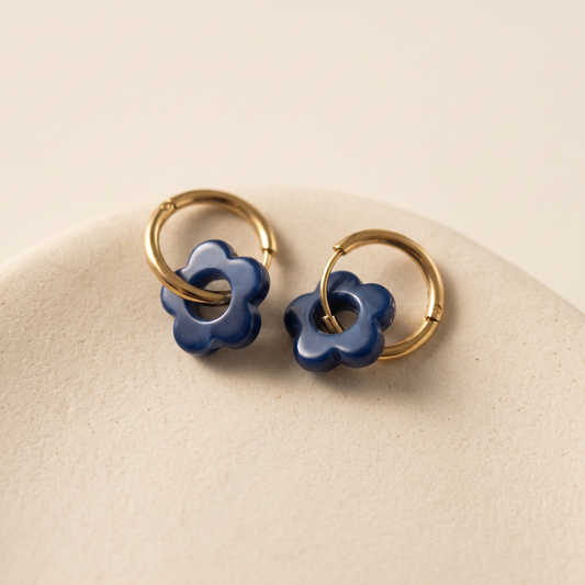 Aros Flora Blue - aro de acero dorado con flor de acrílico azul, sobre fondo neutro